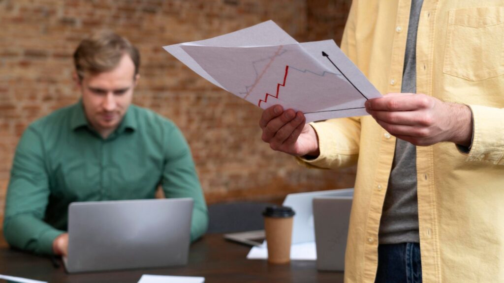 Key Differences Between Sole Proprietorship & LLC Liquidation in Dubai 1 Two professionals analyzing financial reports during a Sole Proprietorship vs LLC Liquidation in Dubai